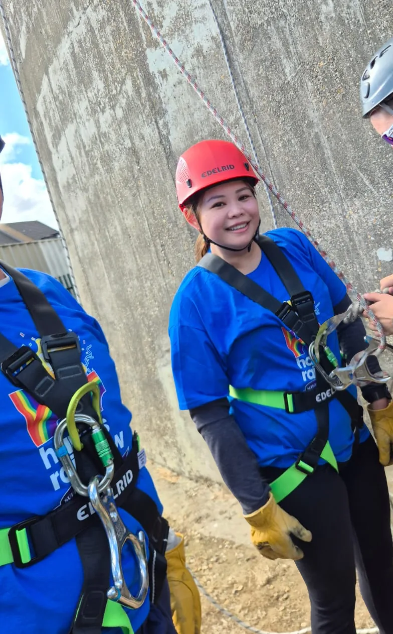 A fundraiser in a Harry's Rainbow shirt, helmet and harness at the foot of the Northampton Lift Tower on 5 September 2026